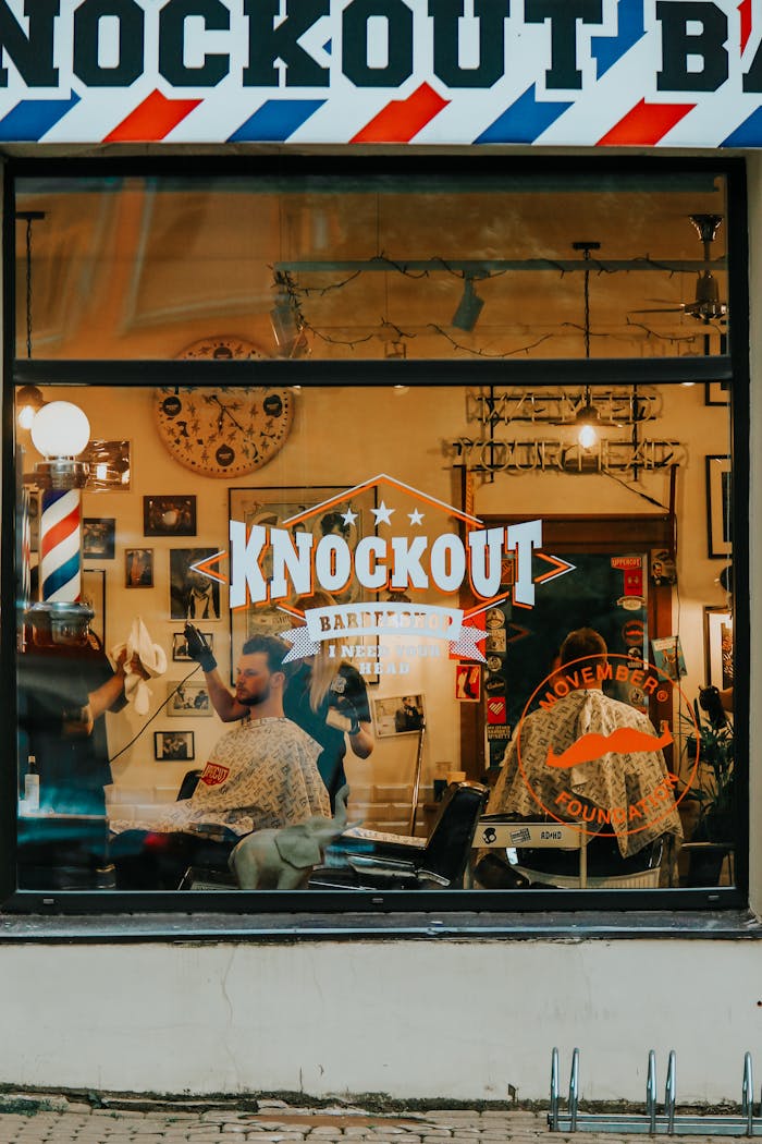 Exterior view of a bustling barber shop in Riga with customers getting haircuts.